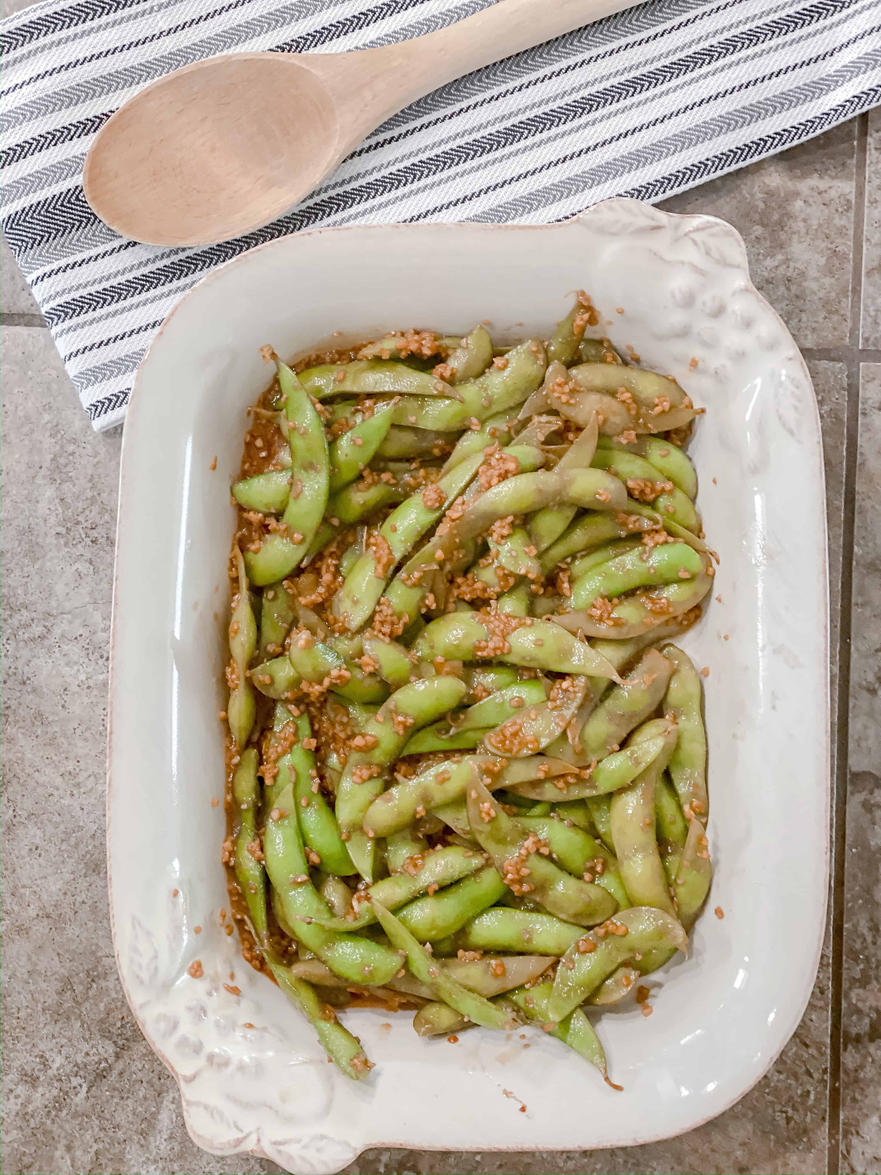 prepared garlic edamame in pretty white dish